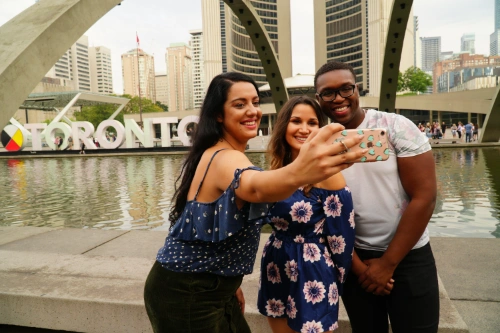 guests on a Toronto city tour taking a photo at city hall